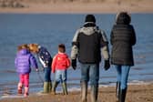 Family playing at the seaside in winter, Instow, Devon, UK. (Photo by: Education Images/Universal Images Group via Getty Images)