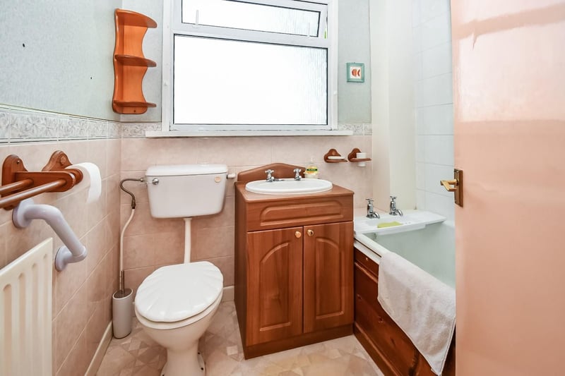 The first floor family bathroom has a bathtub and shower combination as well as a toilet and wash basin.