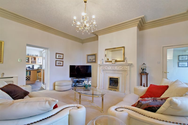The large sitting room with its mantelpiece and log burner.