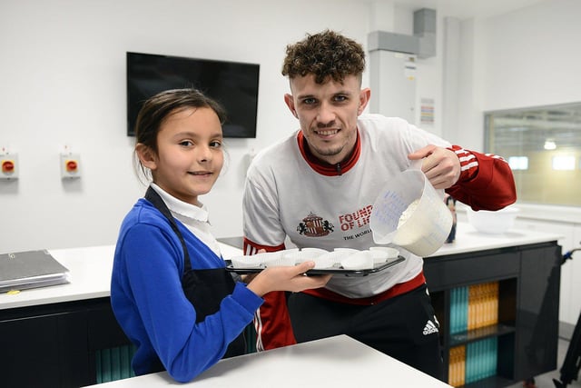 Sunderland AFC defender Tom Flanagan tops up the cupcakes with Alasia Turner during the EFL Day of Action held at the Beacon of Light.