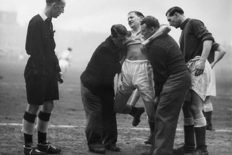 10th March 1951:  Blackpool player Stan Mortensen is carried from the pitch after a collision with Birmingham City goalkeeper Gil Merrick in the FA Cup semi-final at the Maine Road ground, Manchester. The match was a goal-less draw