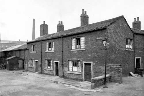 Three cottages om Back Fold. To the left is an industrial property. On the right the end of Sugden Fold can be seen. This property was situated off Theaker Lane. Pictured in June 1935.