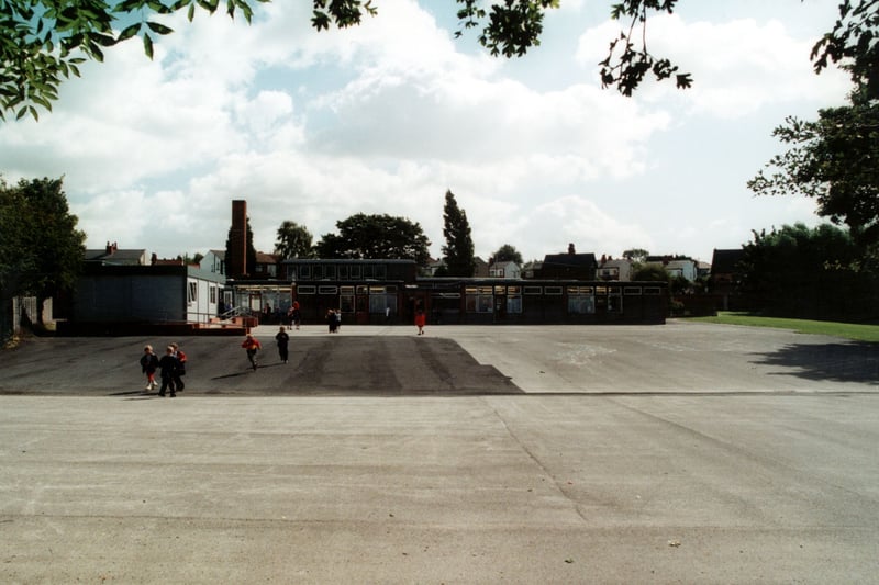 Templenewsam Halton Primary School in Pinfold Lane, looking across the playground from Chapel Street. Children can be seen coming out of the predominantly one storey building and annexe. Pictured in September 2000.