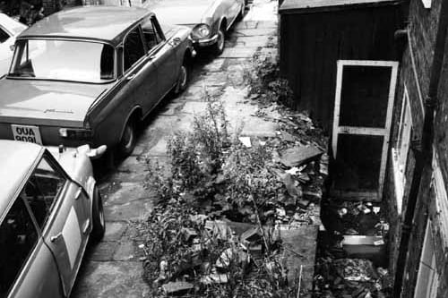 A derelict property in Queen Square awaiting demolition. Cars are parked on the stone flags. Pictured in October 1974.