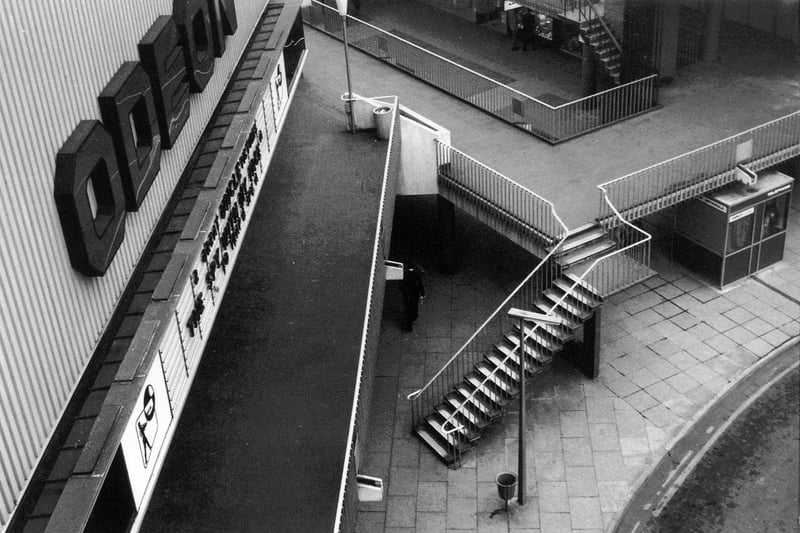The Odeon Cinema inside the newly built Merrion Centre on balcony level. The image was taken before the phase which created Morrison Supermarket and Merrion House. Notice, therefore, that the area in the right foreground is outdoors whereas the same site is nowadays undercover and forms part of a small, indoor piazza between Morrison's supermarket and Woolworth's store.
