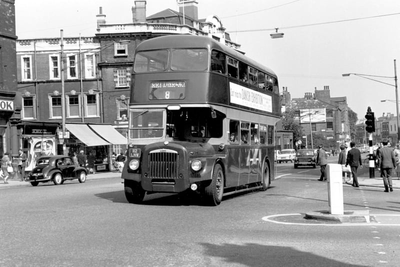 A Daimler CVG6/Roe 112 (1964) bus on North Street with New York Road on the right, August 1965. The registration no is 112 LNW route no 8 to Cottingley. On the left the row of single storey shops were built in the garden of a house which had belonged to the Bischoff Family, then was Hartley Hill, with Leeds Public Dispensary.