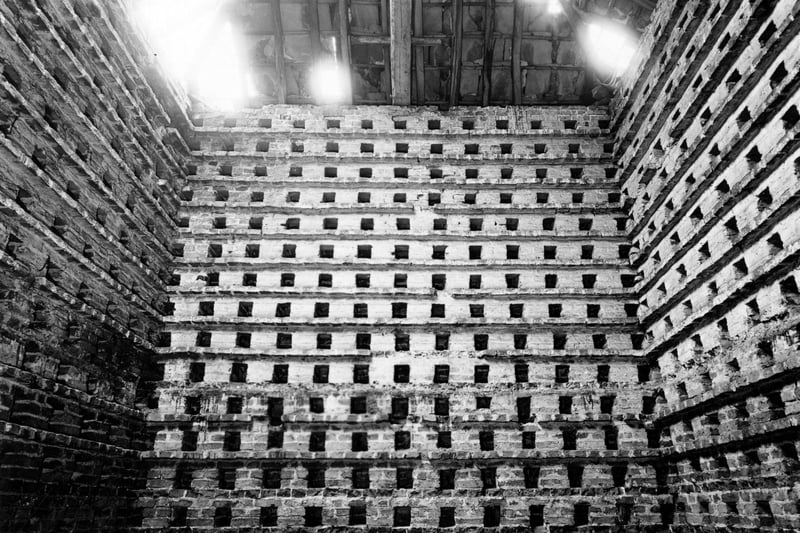 The interior of the old pigeon cote on Pigeon Cote Farm. The cote is lined in brick with many recesses and perches for the birds. Holes in the roof are visible. Pictured in September 1951. 