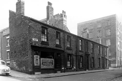 Carlton Terrace is on left on Dorrington Street number 1 is a fish and chip shop. This was the business of Robert Tingle, moving right are 3 then 5 at the corner with Dorrington Road. The factory building on the right is Camrass and Sons Ltd, clothing manufacturers, Dorrington Road Mills. Pictured in August 1959.