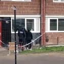 Police point at apparent bullet holes at a flat on Gresley Road.