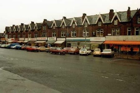 Cars are parked along the road in front of the shops which features the Roundhay Road store on the right in August 1980. 