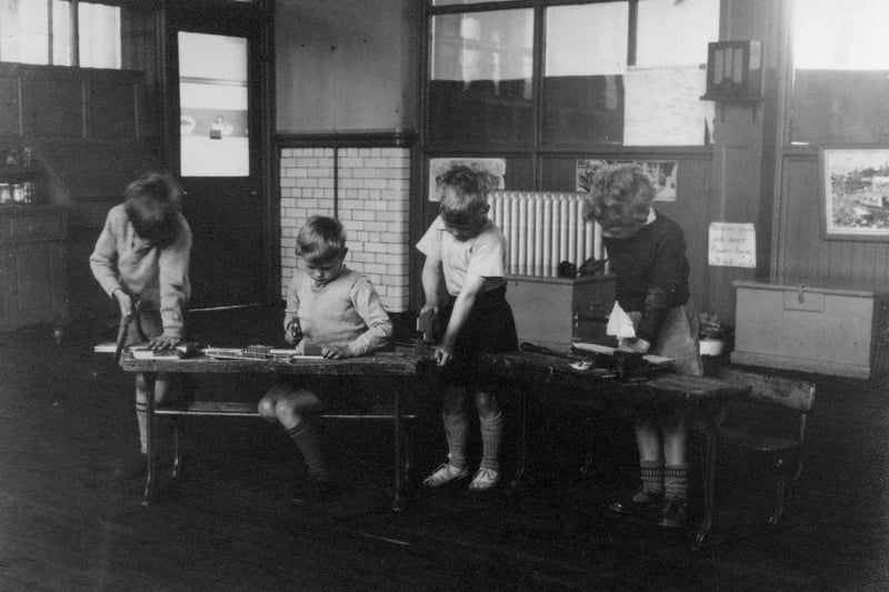 Four boys concentrating on woodwork projects at Bentley Lane Infants School. They are using tools such as saws and hammers. Bentley Lane School was built in the early 1930s, and closed in 2004.