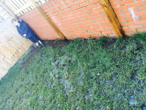 Henry, seven, stood in the flooded garden