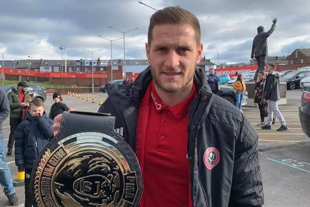 Sheffield United captain Billy Sharp holds the Breed Pro Wrestling championship belt