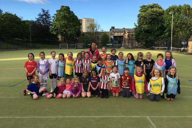 Sam Dyson, coach at Crosspool Juniors Wildcats girls football programme, with some of their young players