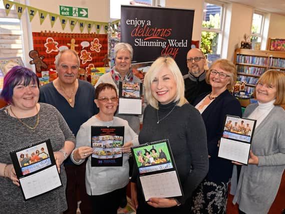 Sprotbrough Library Slimmingworld consultant Amanda Horsman (centre), pictured with members l-r Louise Morton, Jim Breslin, Carmel Proctor, Cheryl Jessop, Jason Horsman, Lyn Robinson and Maureen O'Brien, holding copies of the calendar they have produced to raise money for charity. Picture: Marie Caley NDFP-04-12-18-SlimmingGroupCalendar-1