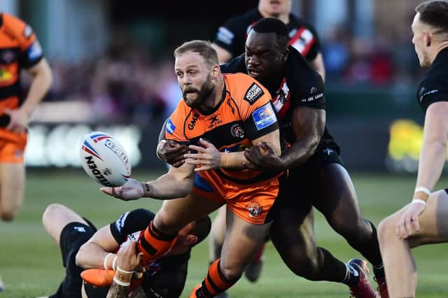 Paul McShane of Castleford Tigers is tackled by Sadiq Adebiyi of London Broncos.