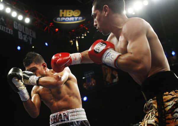 Danny Garcia, right, lands a blow against Amir Khan