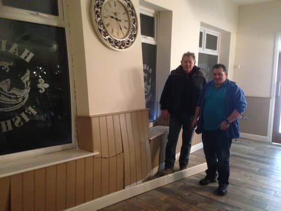 Harry Raouna (r) and builder Trevor Kirsop at Harry's Fish Bar and Restaurant after a car ploughed into the building