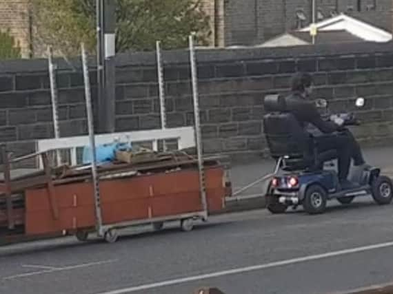 A clip from Danny Addy's YouTube video of a man pulling a huge haul of junk through Barnsley on a mobility scooter. (Photo: Danny Addy).