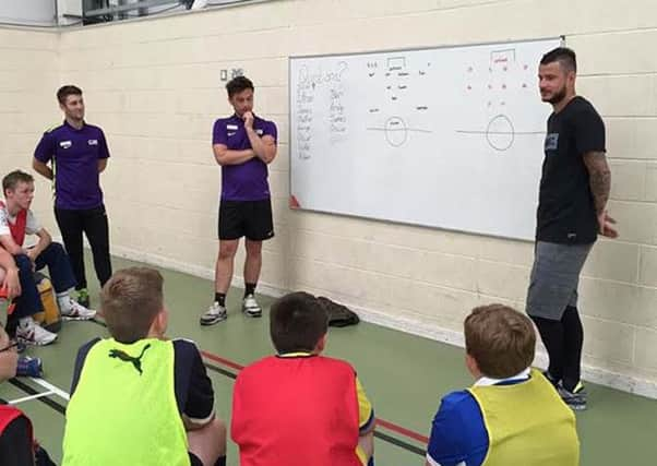 Daniel Pudil with youngsters at the football camp.