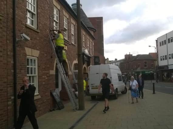 Workers begin removing the signs at the Old Angel.