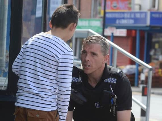 A police officer speaks to a child in Page Hall