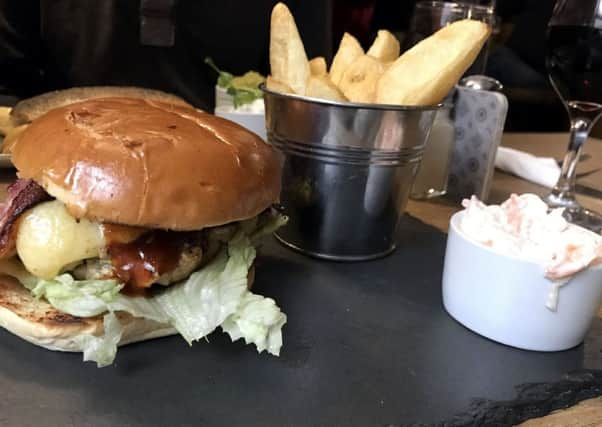 Red Lion pork burger with bacon and Cheddar cheese, homemade chips and coleslaw.