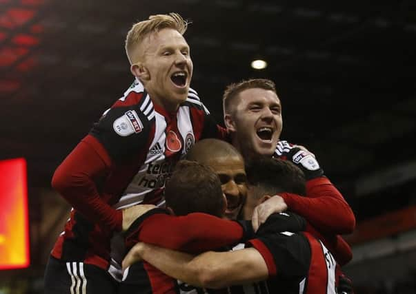 Mark Duffy and John Fleck  jump to help Leon Clarkecelebrate his third goal against Hull City earlier this season. Pic: Simon Bellis/Sportimage