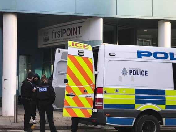 Officers speaking to a witness at the scene outside Howden House in Sheffield city centre