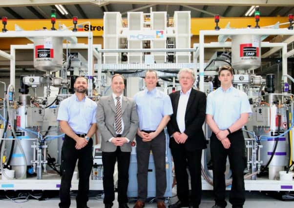 Members of the AMRCs Composite Centre and KraussMaffei in front of the bespoke KraussMaffei RimStar Compact High-Pressure Resin Transfer Moulding system. (l-r) AMRC Development Engineer, Davide Melis, KraussMaffeis Head of R&D and Process Technology RPM Division, Sebastian Schmidhuber, AMRC Research Engineer, Darren Wells, KraussMaffeis RPM Business Manager UK, Stephen Lambert and AMRC Composites Technician, Ricky Rowett.