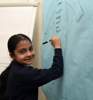 Sara writes words associated with bullying during an anti bullying activity at Oasis Academy Fir Vale.